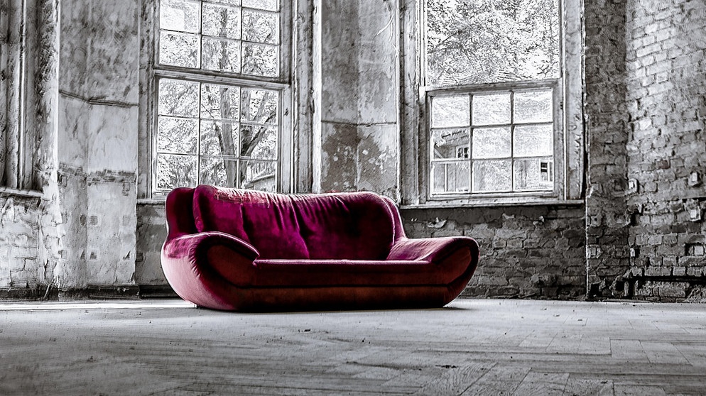 Rotes Sofa in leerem Raum | Bild: picture alliance / Zoonar | schattenspiel1
