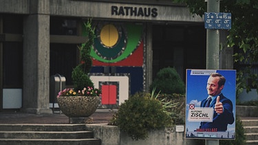 Hindafing - Folge 1: Das Rathaus von Hindafing mit einem Wahlplakat von Zischl (Maximilian Brückner) | Bild: Günther Reisp