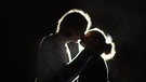 Ein Mann und eine Frau küssen sich im Gegenlicht | Bild: BR