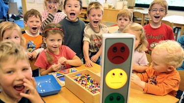 Kinder probieren eine "Lärmampel" aus: Wenn die Kinder sehr laut schreien, zeigt die Ampel "Rot". Im Moment steht die Ampel auf "Gelb". | Bild: picture-alliance/dpa