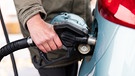 Eine Frauenhand befüllt ein Auto an einer Tankstelle mit Kraftstoff | Bild: BR/Leon Baatz
